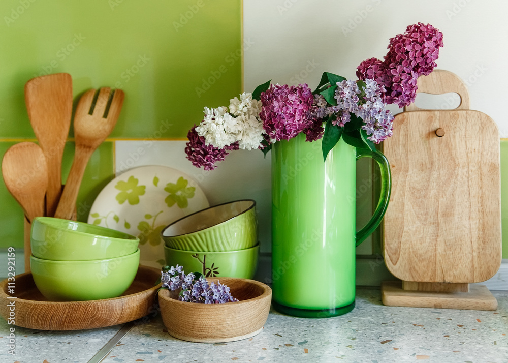 Kitchen Ceramic and Wooden Tableware,Bouquet of Lilac in the Green Plastic Pitcher. Kitchen Ceramic and Wooden Tableware,Bouquet of Lilac in the Green Plastic Pitcher.