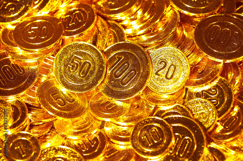 Golden coins piled in a heap of background