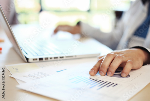 Hands of financial manager taking notes when working © opolja