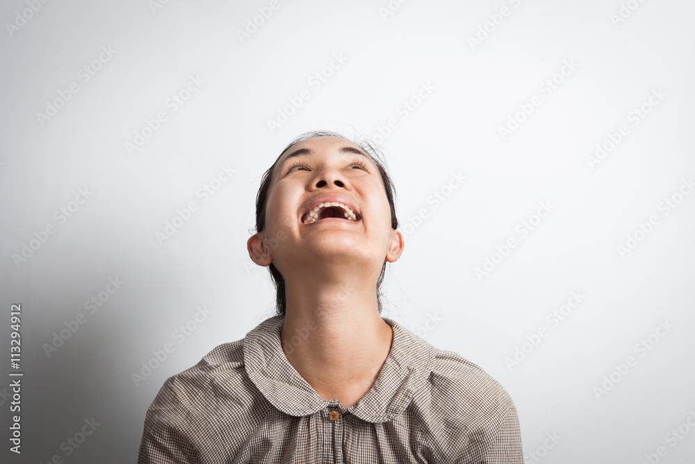funny happy asian woman looking up - isolated over a gray background. funny happy asian woman looking up - isolated over a gray background.