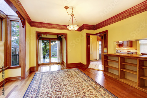 Elegant empty living room with yellow walls, carved wood doorway