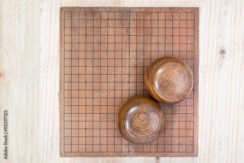 two wooden bowls over empty go game board photo