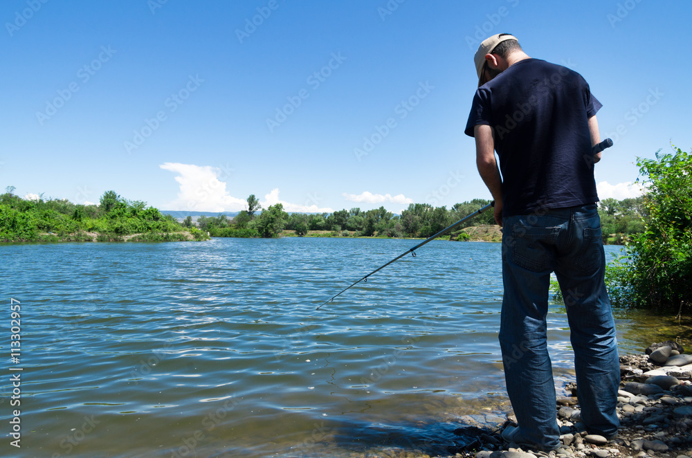 A young man is fishing with spinning