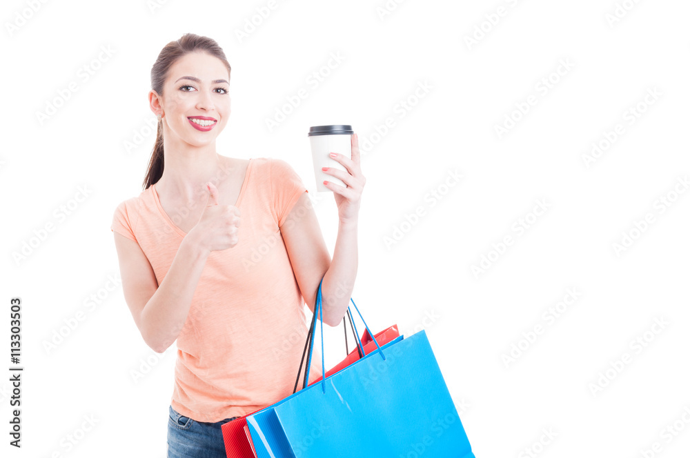 Shopping woman showing thumb up gesture for cup of coffee Shopping woman showing thumb up gesture for cup of coffee