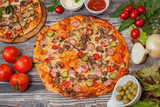  pizza  with mushrooms and pepperoni , tomatoes