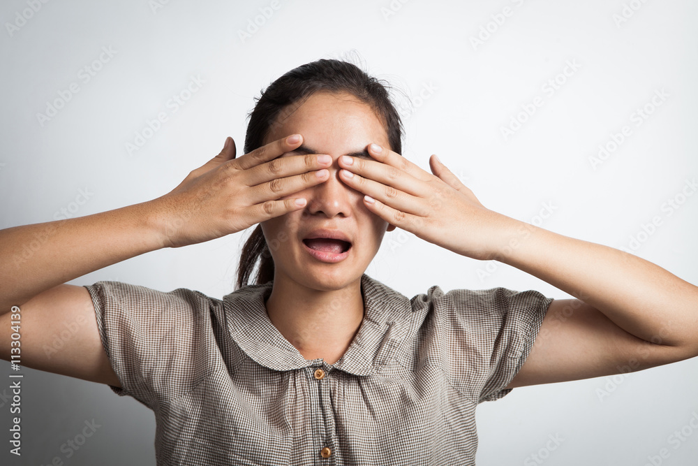 Young asian woman covering her eyes with her hands and counting over gray background. Young asian woman covering her eyes with her hands and counting over gray background.