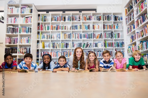 Obraz na plátně Teacher reading books to her students