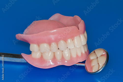 Denture on blue background with mirror