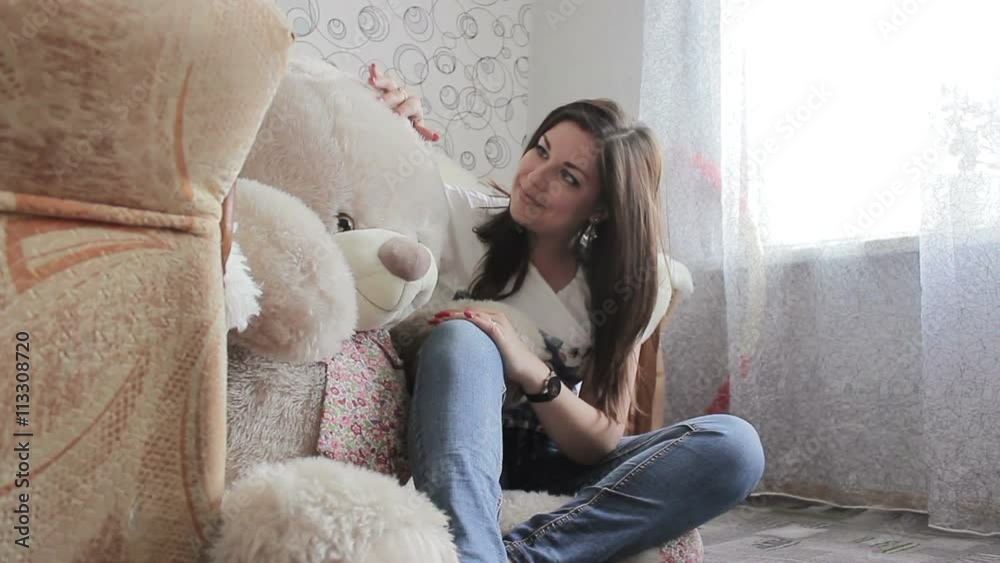 Young woman hugging teddy bear opening eyes and smiling at camera Young woman hugging teddy bear opening eyes and smiling at camera
