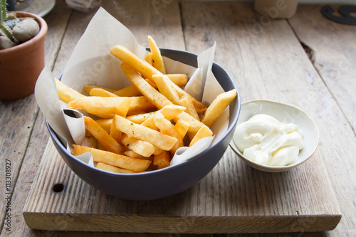 Delicious French fries or potato fries with mayonnaise on wooden background photo