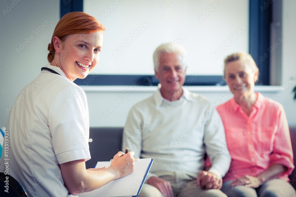 Obraz premium Doctor writing medical report of senior couple