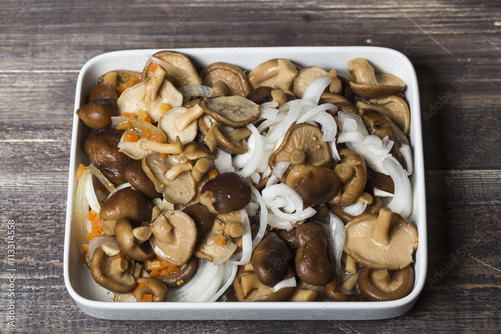 Marinated mushrooms with onion on white plate Marinated mushrooms with onion on white plate