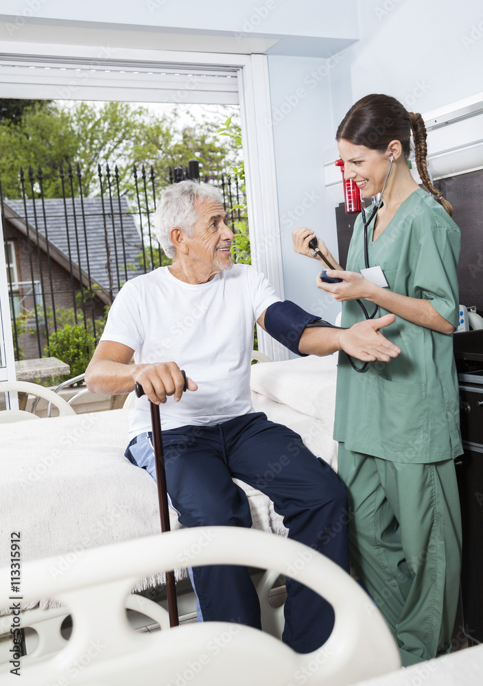 Nurse Checking Blood Pressure Of Patient In Rehab Center Nurse Checking Blood Pressure Of Patient In Rehab Center