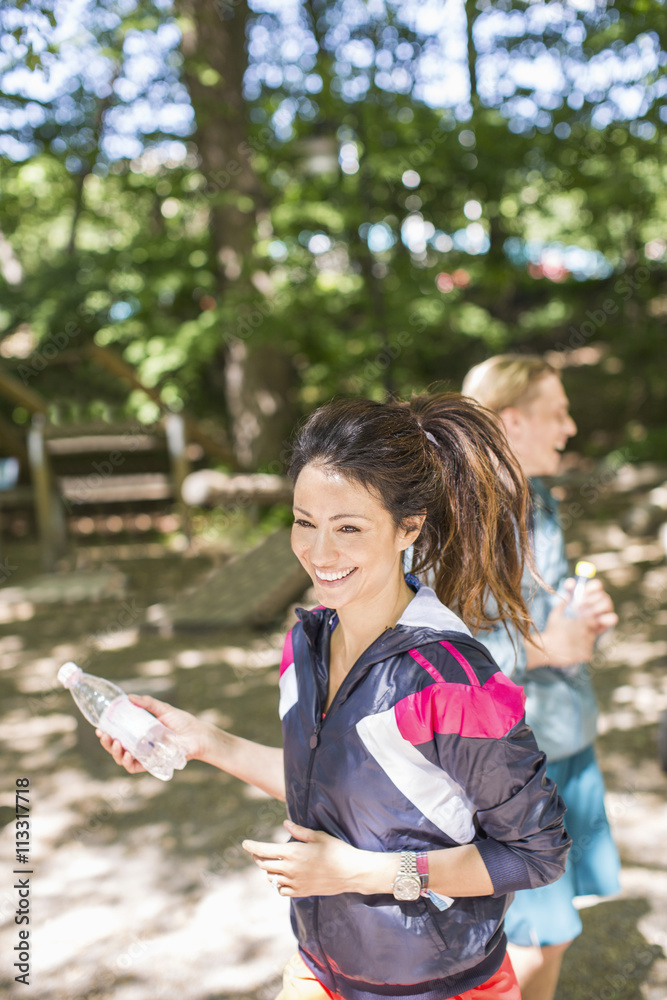 Happy couple holding water bottles at outdoor gym Happy couple holding water bottles at outdoor gym