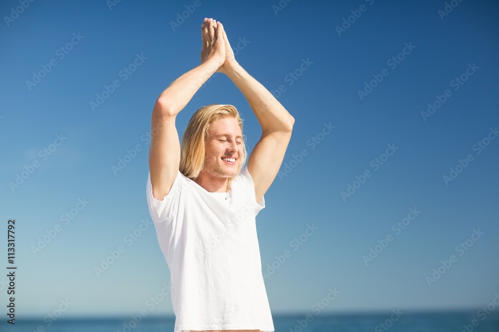 Man performing yoga on beach Man performing yoga on beach