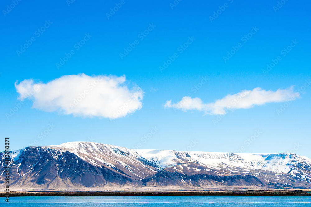 Mountains with snow by the ocean