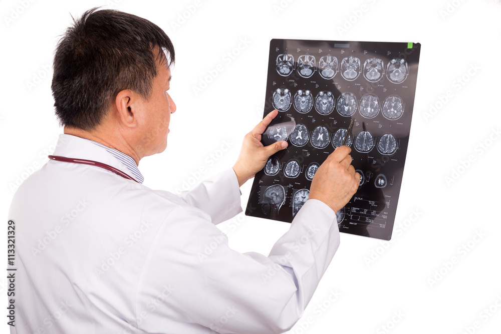 Matured Asian neurology medical doctor examining head MRI images Matured Asian neurology medical doctor examining head MRI images