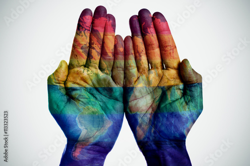 world map and rainbow flag in the hands photo
