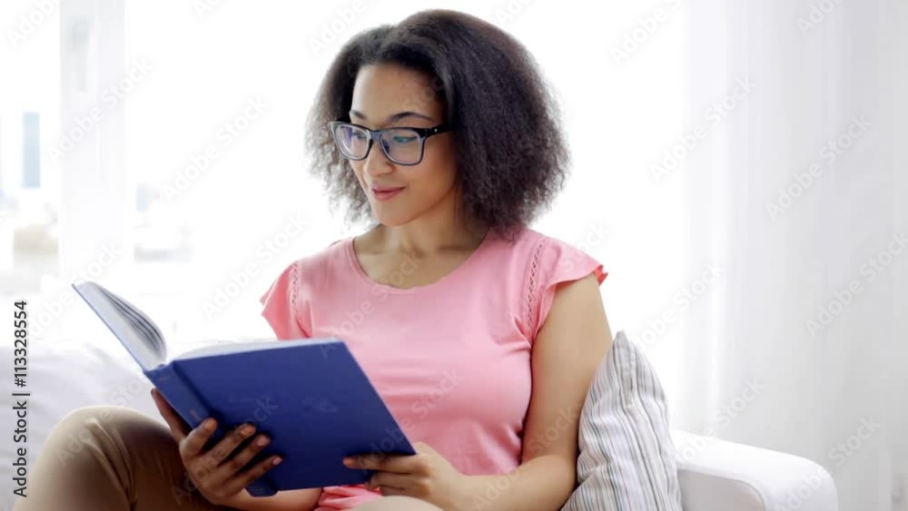 african american young woman reading book at home african american young woman reading book at home