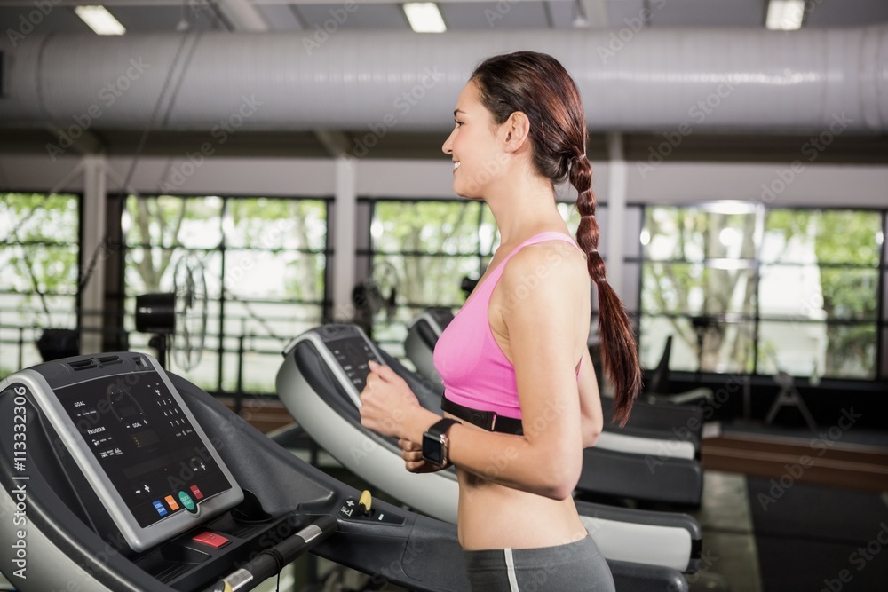 Woman using smart watch on treadmill Woman using smart watch on treadmill