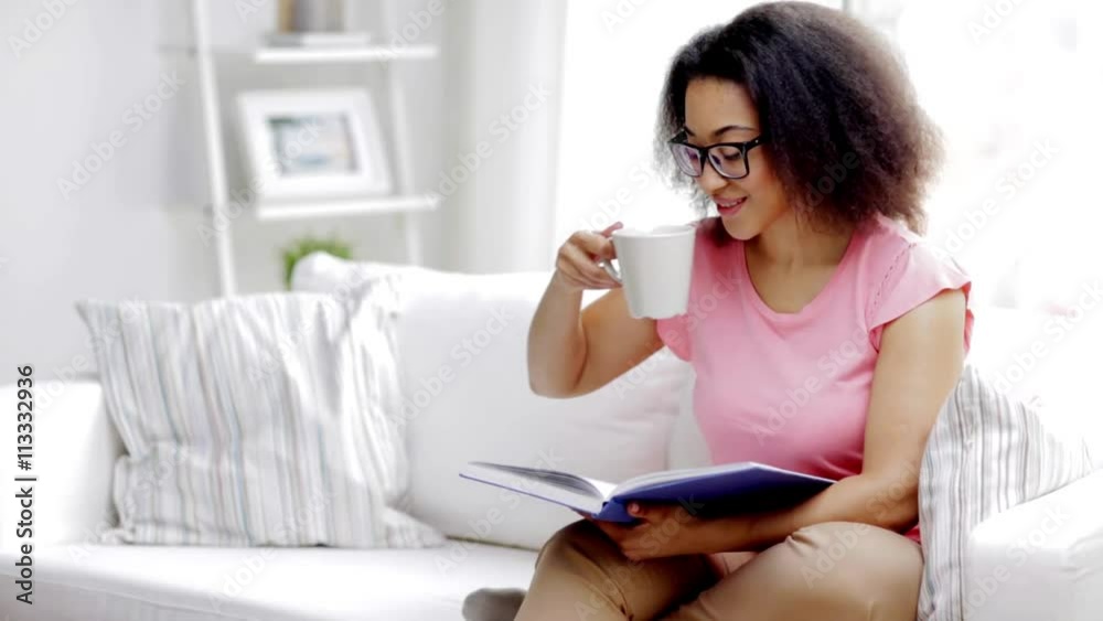 african woman reading book and drinking tea african woman reading book and drinking tea