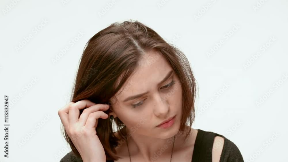 Sad grumpy girl on a white background. Close up. Slow motion Sad grumpy girl on a white background. Close up. Slow motion