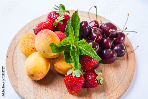 fruits and berries on a wooden cutting board