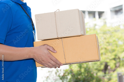 Delivery man holding a parcel box, Delivery service concept © comzeal