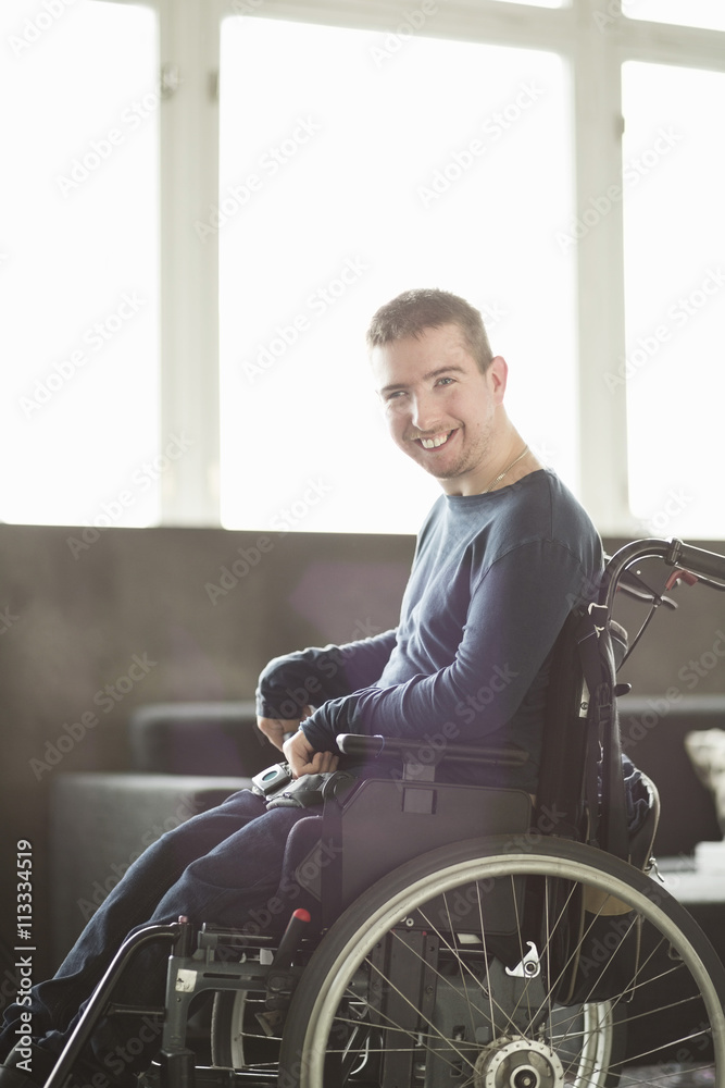 Portrait of happy disabled businessman sitting on motorized wheelchair in office Portrait of happy disabled businessman sitting on motorized wheelchair in office