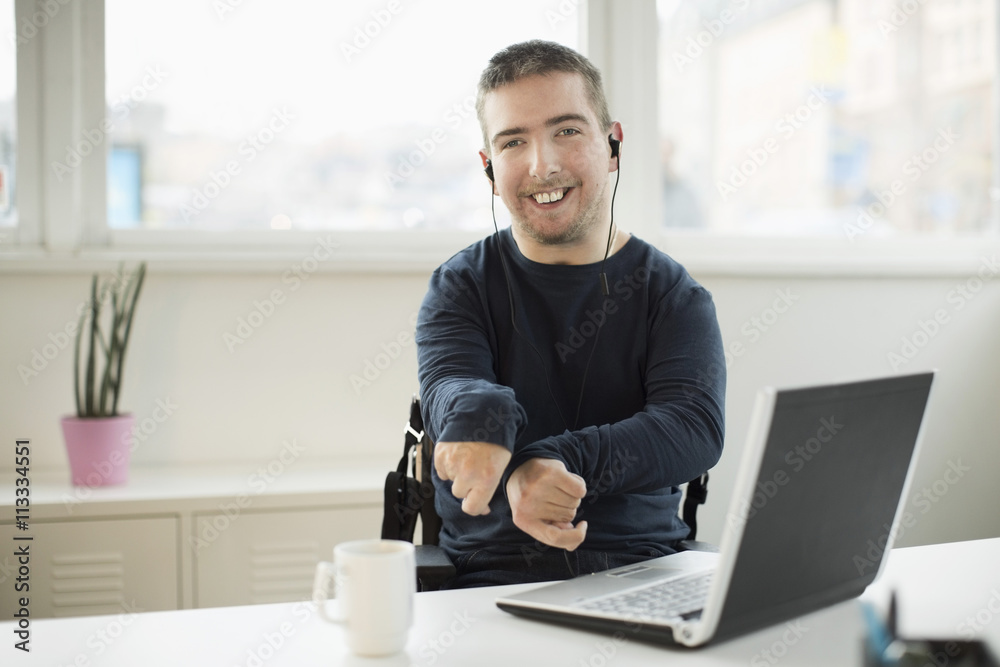 Young man sitting in wheelchair at office
Young man sitting in wheelchair at office