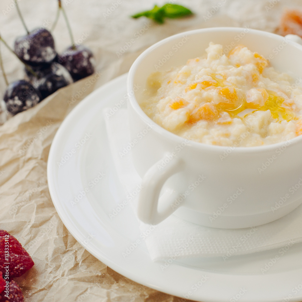Close up millet porridge with pumpkin. Parchment background. Square crop. Close up millet porridge with pumpkin. Parchment background. Square crop.