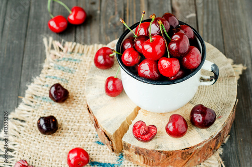  Summer berries and fruits, ripe red cherry in an iron bowl on a wooden background , rustic style