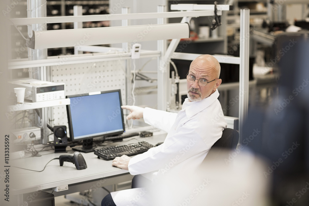 Engineer pointing at computer in manufacturing industry Engineer pointing at computer in manufacturing industry