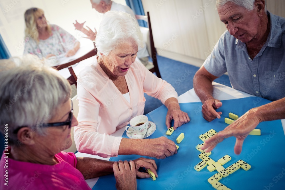 Obraz premium Group of seniors playing dominoes