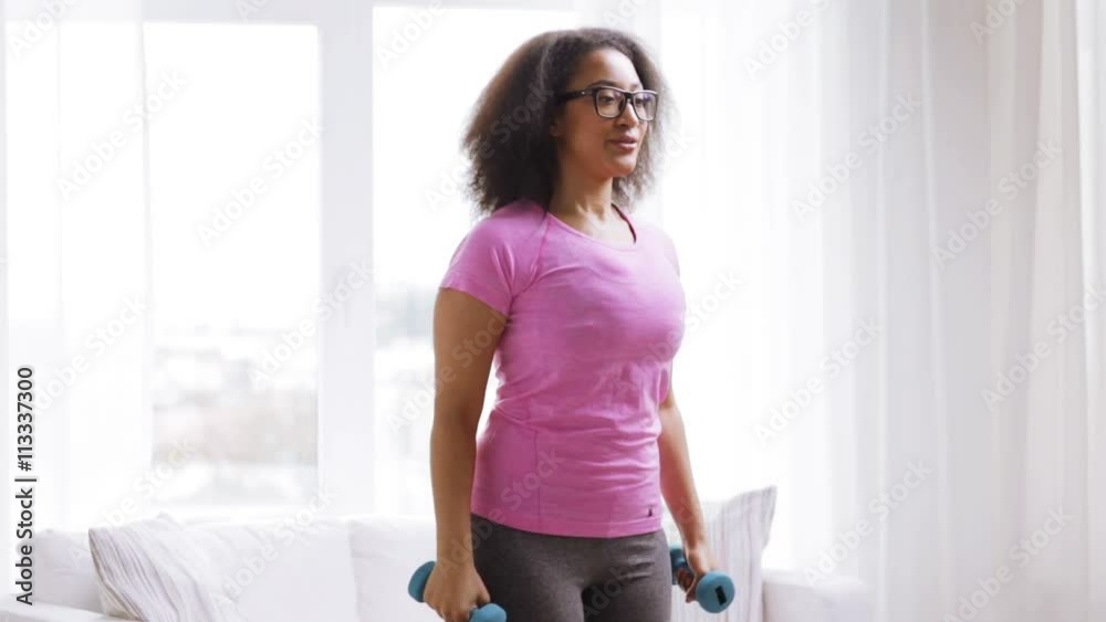 african woman exercising with dumbbells at home african woman exercising with dumbbells at home