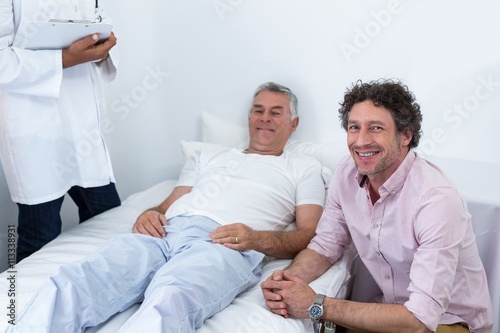 Man sitting next to patient smiling