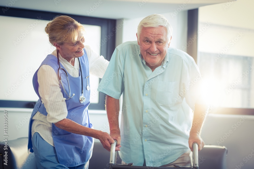 Female doctor helping senior man to walk with walker Female doctor helping senior man to walk with walker