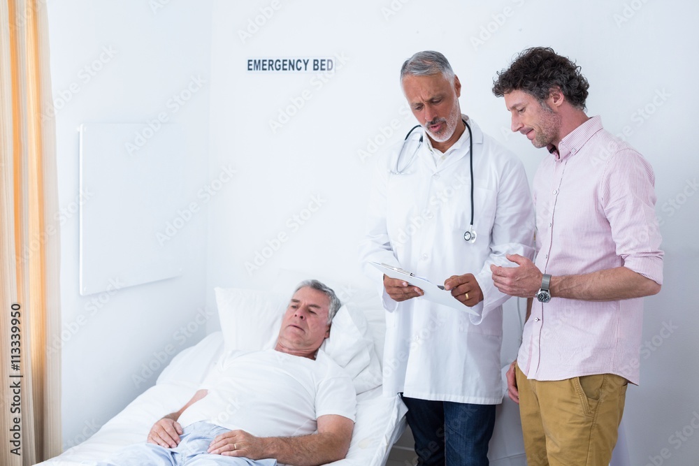 Fototapeta premium Male doctor discussing medical report with man