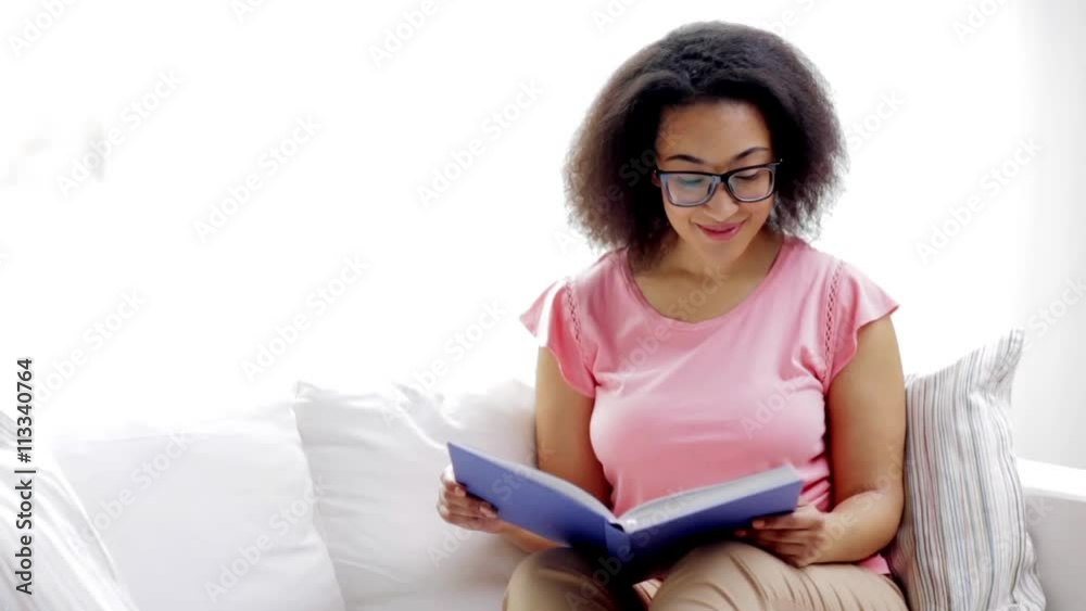 african american young woman reading book at home african american young woman reading book at home