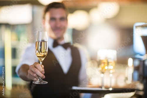 Canvas Print Waiter offering a glass of champagne