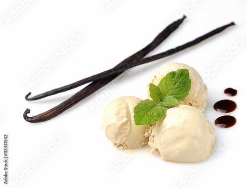 Vanilla ice cream in bowl with mint and vanilla sticks
 photo