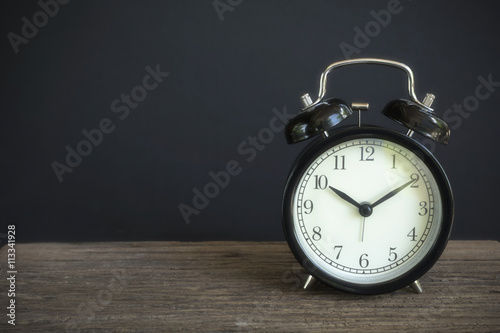 Alarm clock on wood with a black background