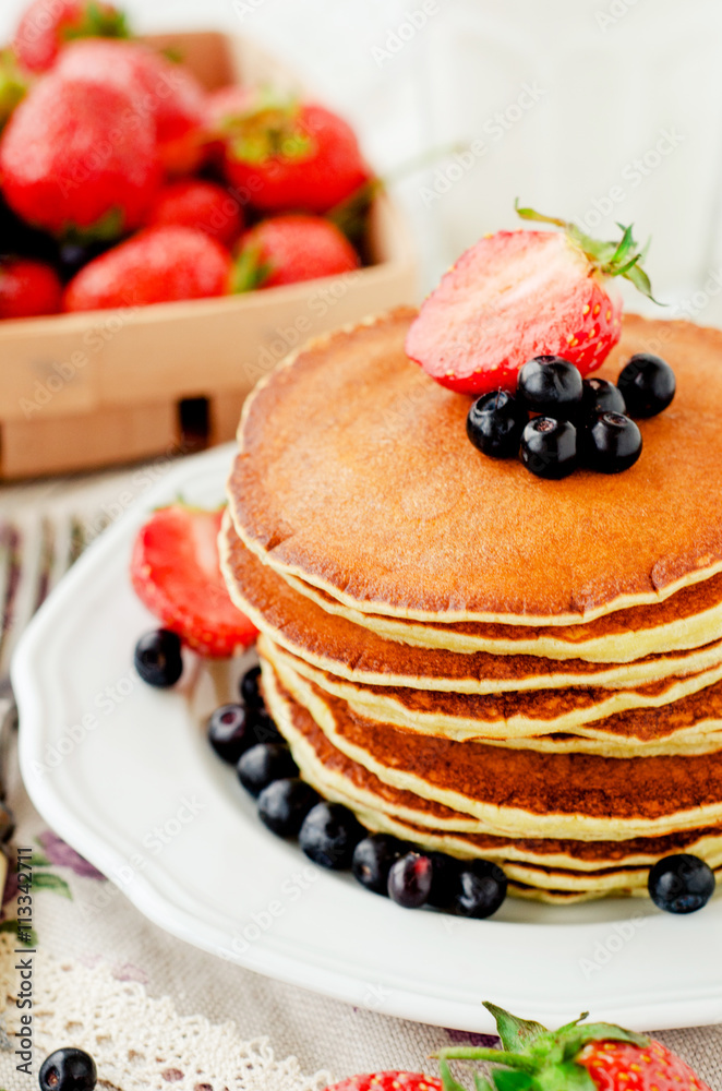 easy hearty and healthy breakfast , American pancakes with berries , blueberries and strawberries with milk on a wooden background
easy hearty and healthy breakfast , American pancakes with berries , blueberries and strawberries with milk on a wooden background