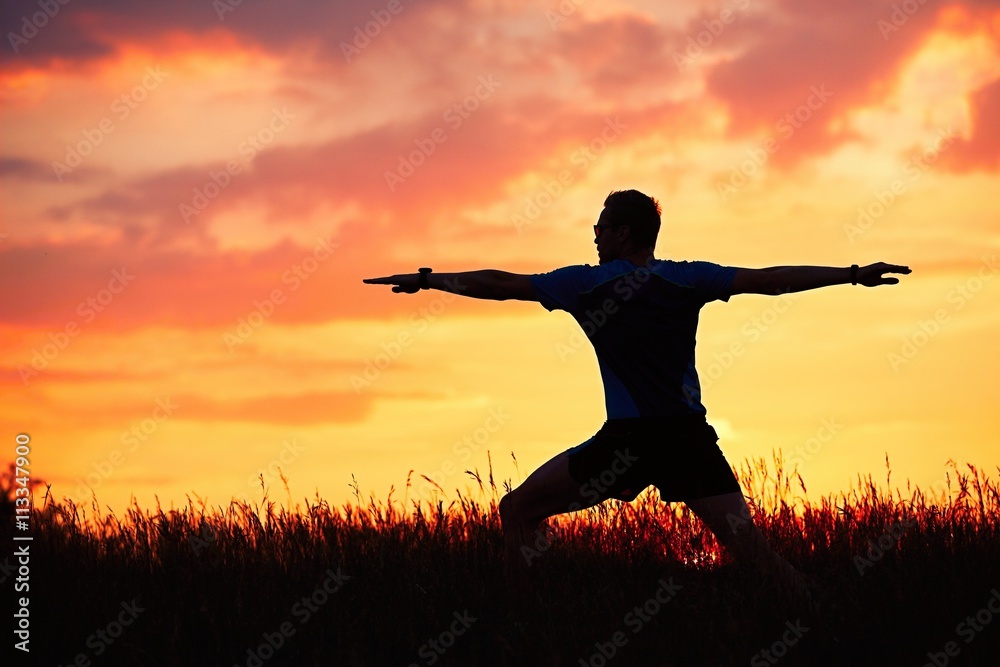 Man is practicing yoga during sunset Man is practicing yoga during sunset