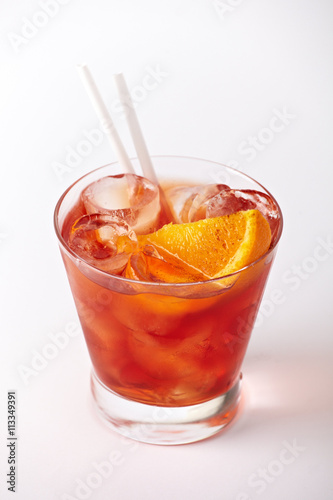 Orange cocktail drink with ice closeup isolated on white background