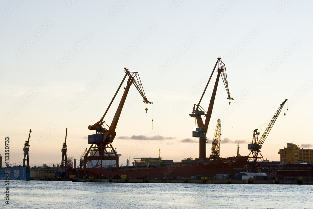 Silhouette of cranes in commercial dock at sunset Silhouette of cranes in commercial dock at sunset