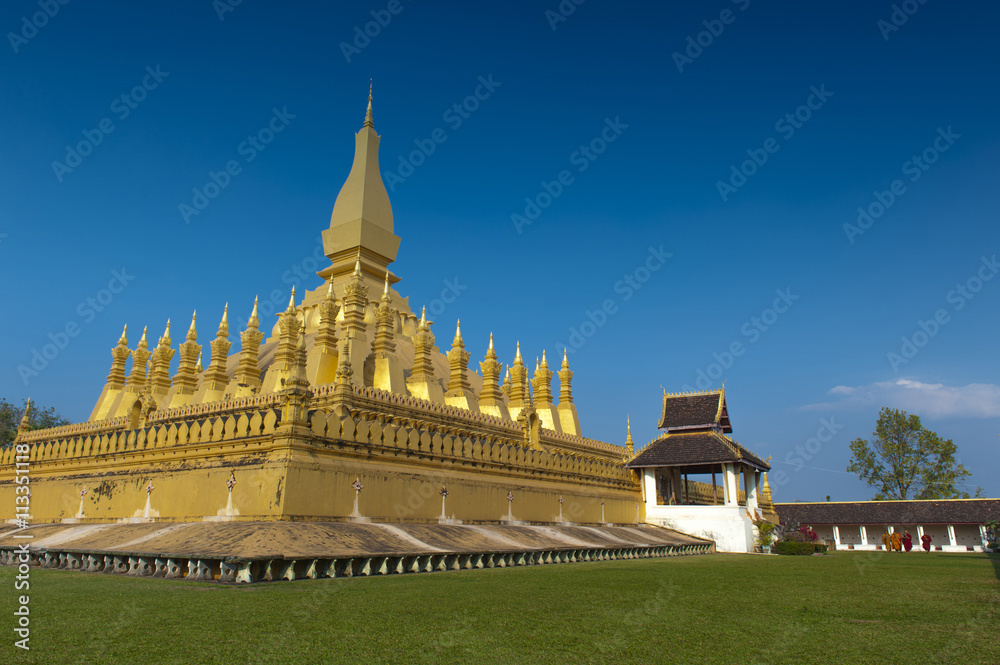 Group of Buddhist monks walking around That Luang Stupa, landmark of Vientiane, Lao PDR