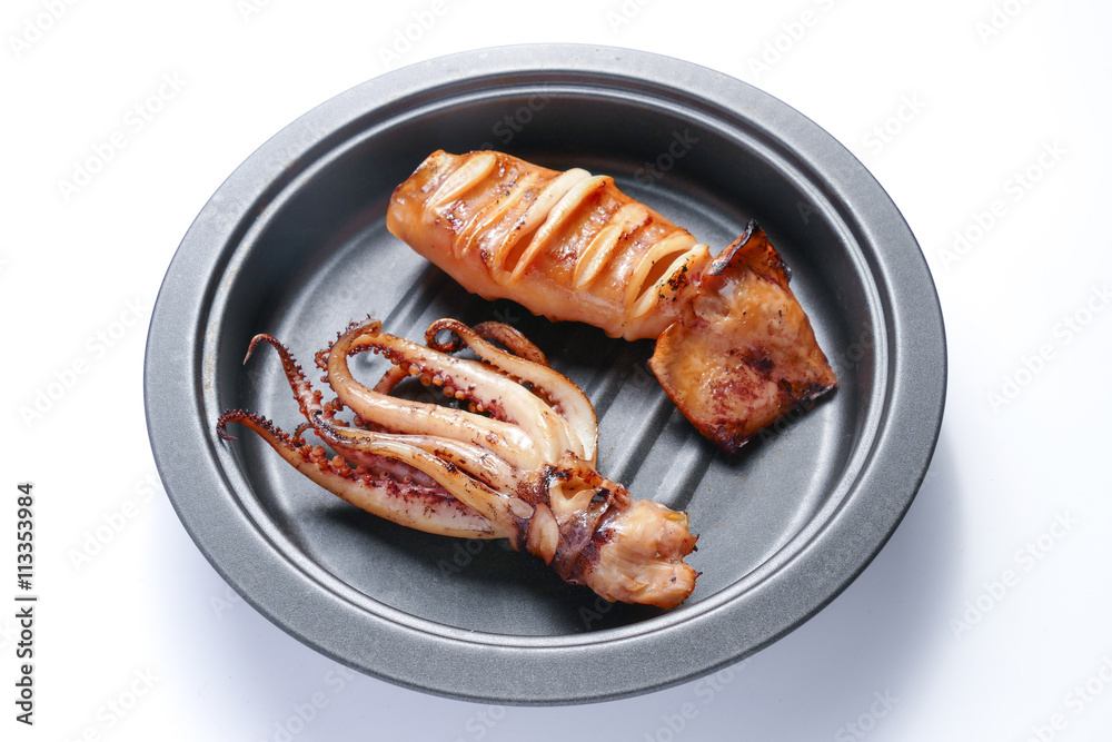 Grilled squid on frying pan over white background Grilled squid on frying pan over white background