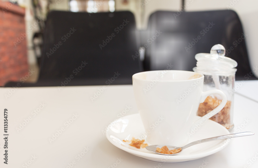 cup of coffee and sugar with magazine on white wood table cup of coffee and sugar with magazine on white wood table