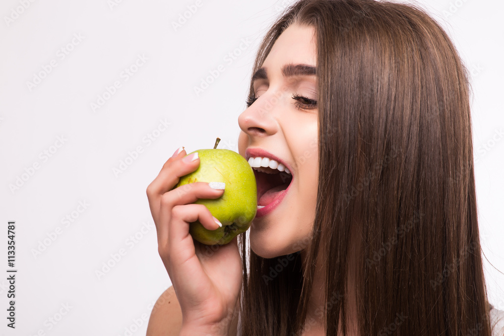 Young girl eat apple. Female teeth and apple. Healthy eating on white background Young girl eat apple. Female teeth and apple. Healthy eating on white background